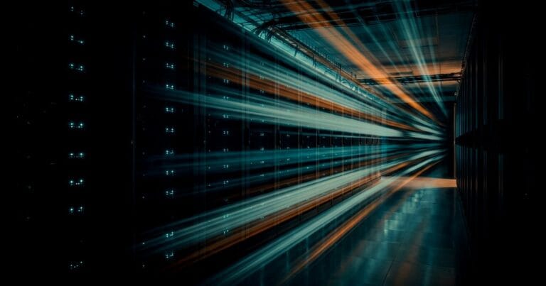 Long-exposure teal and orange light trails racing down a dark server-rack corridor toward a vanishing point on the right, for a guide to speeding up WordPress for Arabic sites.